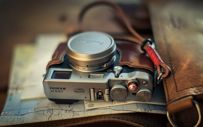 resan begrepp, en gammal kamera, en karta, resor koncept, Fuji X100T