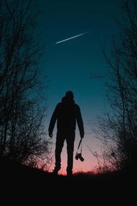 Silhouette eines mannes der im wald bei sonnenuntergang spaziert