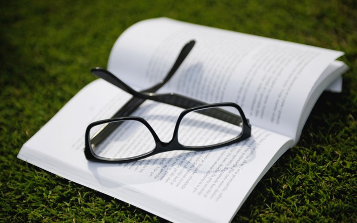 glasses on a book, green grass, mood, white paper, reading book concepts