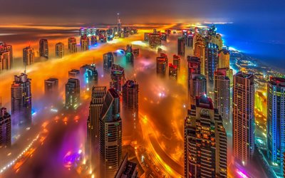 Dubai, UAE, bright colored city lights, metropolis, skyscrapers above the clouds, night, modern architecture