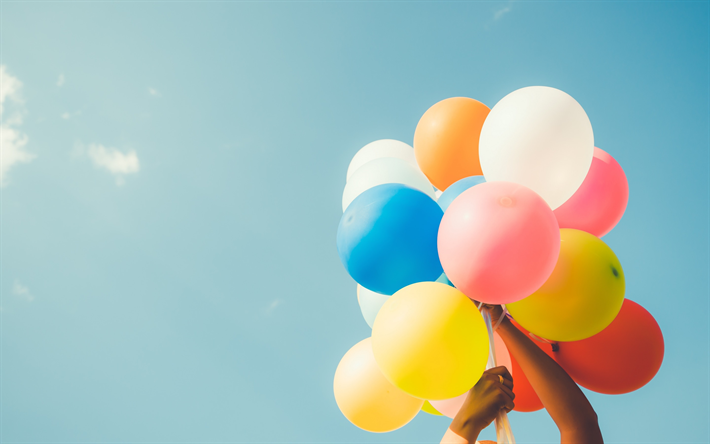 colorful balloons in the hand, bundle of balloons, blue sky, mood concepts