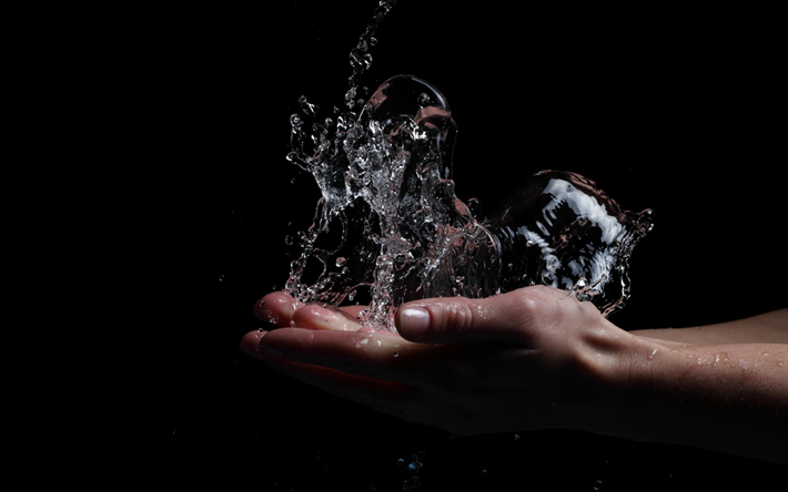 de l&#39;eau dans les mains, les &#233;claboussures de l&#39;eau, les mains sur un fond noir, l&#39;eau de concepts, d&#39;&#201;conomiser de l&#39;eau