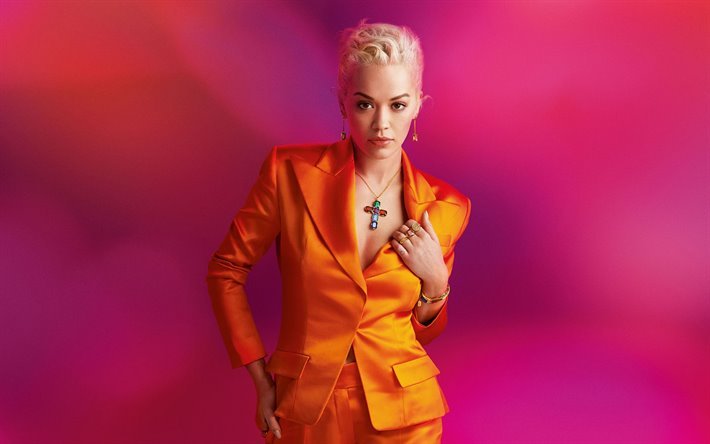 Rita Ora, retrato, cantante brit&#225;nico, de naranja disfraz, sesi&#243;n de fotos, con fondo rojo, estrellas brit&#225;nicas