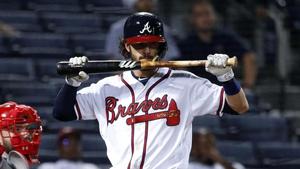 a baseball player is holding a bat while he is on the field baseball wallpaper