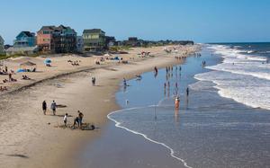 a beach with people walking on it outer banks wallpaper