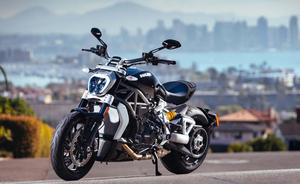 a black motorcycle parked on the side of the road Wallpaper