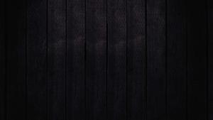a black wooden background with a light shining on it dark wallpaper