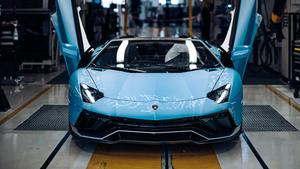 a blue lamborghini sports car is sitting in a factory lamborghini wallpaper