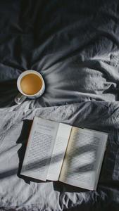 a book and cup of tea on a bed dark aesthetic wallpaper