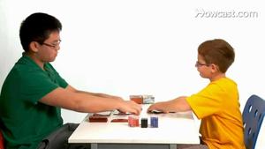 a boy and a girl playing cards at a table trading wallpaper