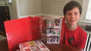 a boy holding a red binder full of cards trading wallpaper