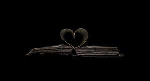 A broken heart shattering into pieces against a dark black background. broken heart black wallpaper