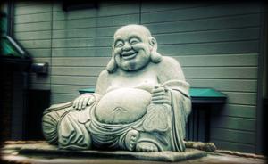 a buddha statue sitting on a rock buddha wallpaper