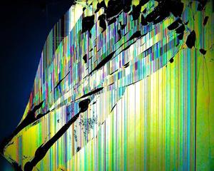 A damaged laptop screen with a web of broken glass reflecting the light cracked screen wallpaper