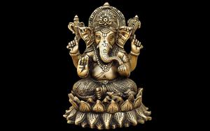 a gold ganesha statue on a black background ganesh wallpaper