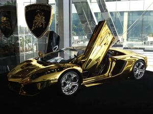 a gold lamborghini sports car is on display in a showroom lamborghini wallpaper