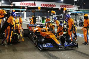 a group of people working on a racing car f1 wallpaper