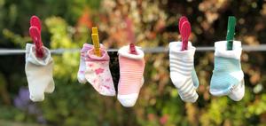 a group of socks hanging on a clothes line matching wallpaper