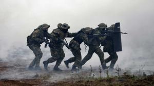 a group of soldiers are running through a field with smoke indian army wallpaper