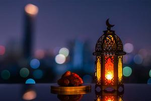 a lantern with a candle and a city view islamic wallpaper