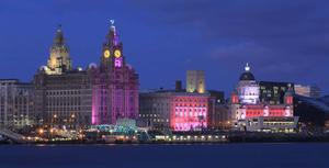 a large building is lit up pink liverpool wallpaper