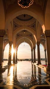 a large pool with arches and a sun setting behind it islamic wallpaper