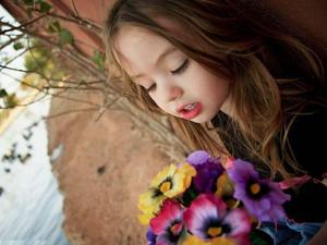 a little girl holding a bouquet of flowers whatsapp dp wallpaper