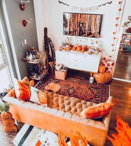 a living room decorated for halloween with orange pumpkins and orange decor fall aesthetic wallpaper
