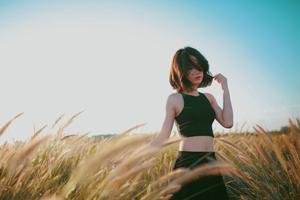 A lonely girl walking in a sunlit field girl wallpaper