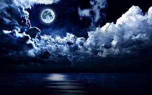 A magical blue hue is illuminating the full moon reflecting off a calm night sea. moon wallpaper