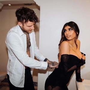 a man and woman in a bathroom with a tattooed man mia khalifa wallpaper