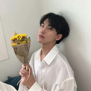 a man holding a bouquet of flowers aesthetic boy wallpaper
