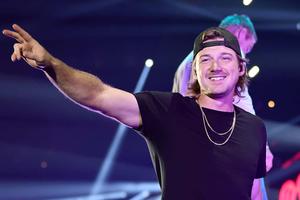 a man in a black hat is pointing at the crowd morgan wallen wallpaper