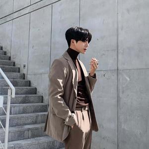a man in a brown suit standing on steps aesthetic boy wallpaper