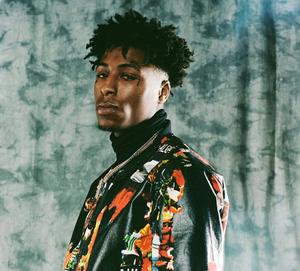 a man in a colorful jacket standing in front of a wall nba youngboy wallpaper