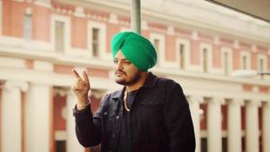 a man in a green turban is pointing at a building Wallpaper