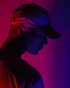 a man in a hat with a red and blue light behind him Wallpaper