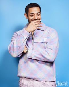 a man in a plaid shirt is posing for a photo Wallpaper