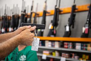 a man is holding a gun in a store gun wallpaper
