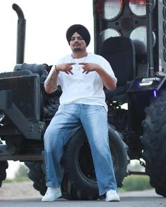 a man is sitting on a tractor Wallpaper