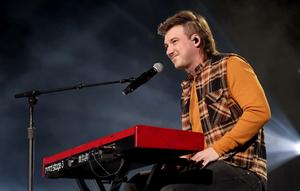 a man playing a keyboard while singing morgan wallen wallpaper