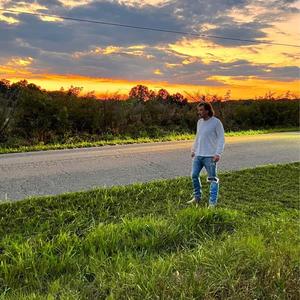 a man standing on the side of a road at sunset morgan wallen wallpaper