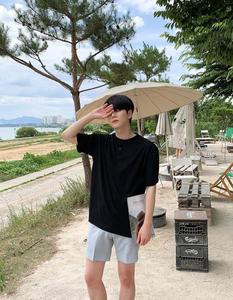 a man wearing a black t - shirt and shorts aesthetic boy wallpaper