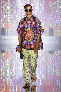 a man wearing a colorful shirt and pants on the runway Wallpaper