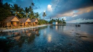 A mesmerizing sunset over a serene lake with a wooden pier and lush vegetation 4k ultra hd wallpaper