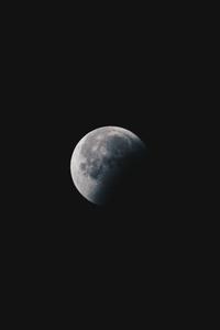 a moon is seen in the dark sky Wallpaper