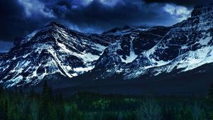 a mountain range with trees and a dark sky dual monitor wallpaper