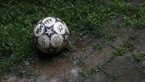A muddy football lays unclaimed in the grass. football wallpaper