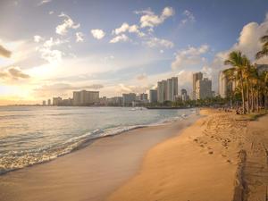 A peaceful beach with a calm blue ocean and majestic mountains beach wallpaper