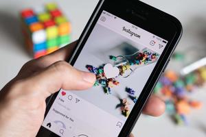 a person holding a cell phone and taking a picture of a cube instagram wallpaper